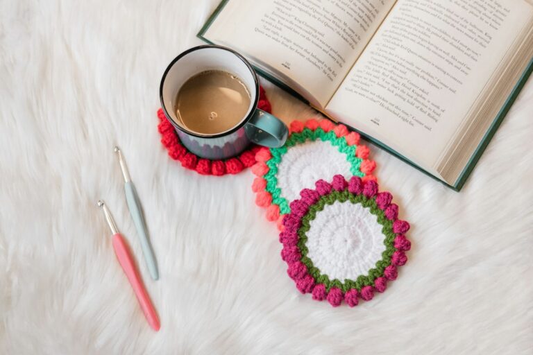A handmade crochet coaster beside a coffee cup and book
